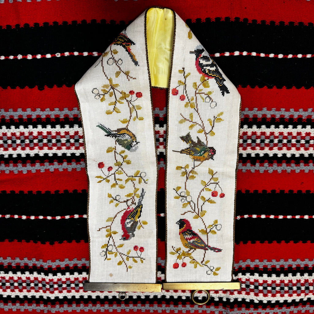 Embroidered tie with bird design on a striped fabric background