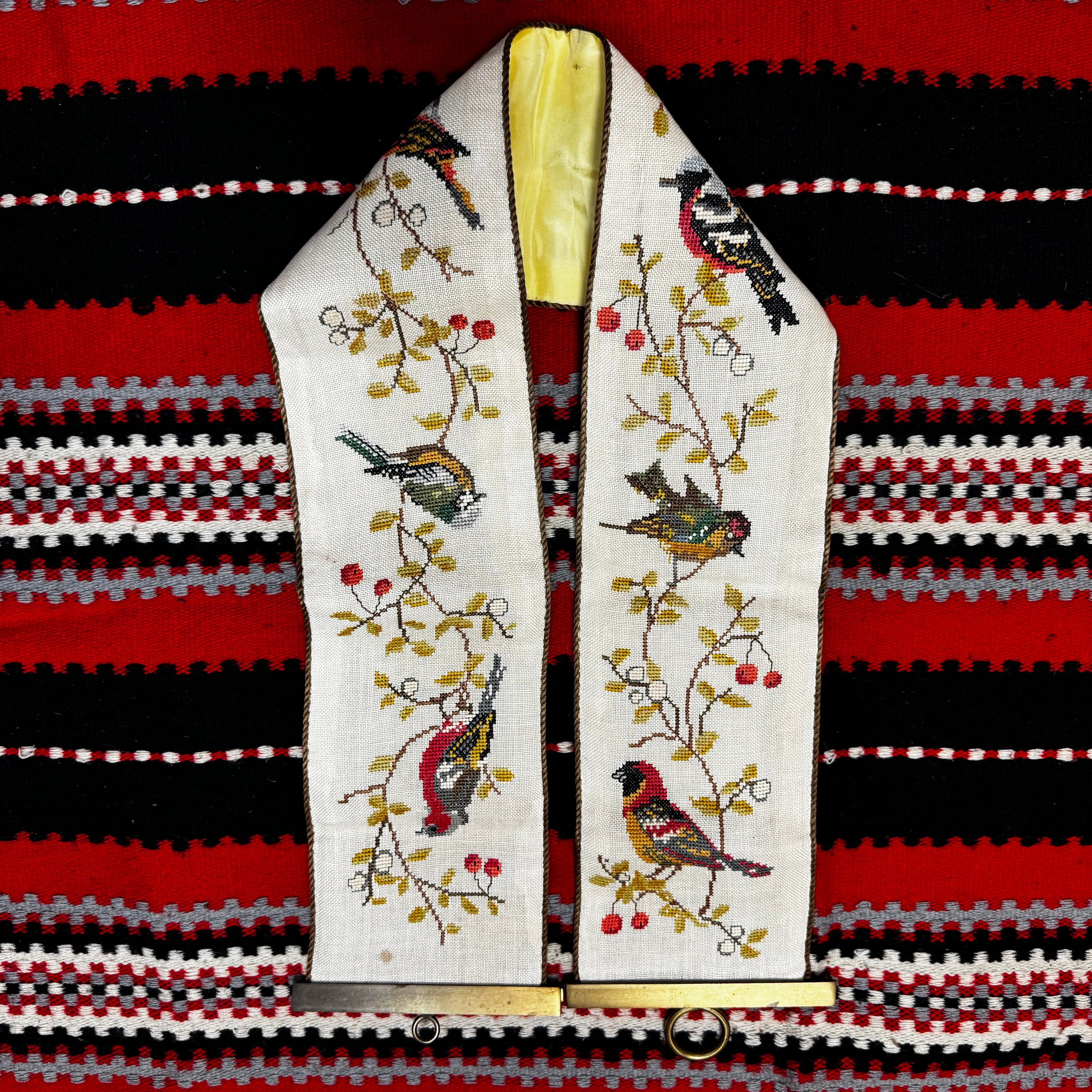 Embroidered tie with bird design on a striped fabric background